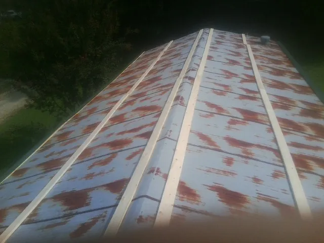 Rusted metal roof panels with new wood purlins before replacement — Storm Damage Roof Repair in Saegertown by Roofing Brothers
