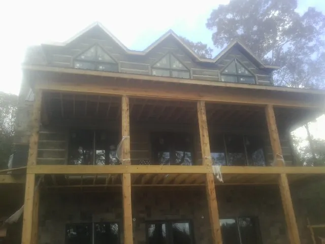 Dormers and porch framing on a large log home under construction — Roof Coating work by our crew in Saegertown