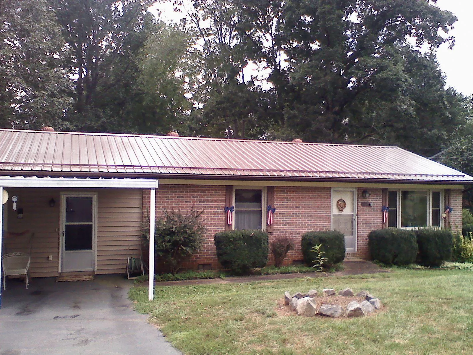 Bronze metal roof and carport on a brick ranch home — Roof Repair work by our crew in Saegertown