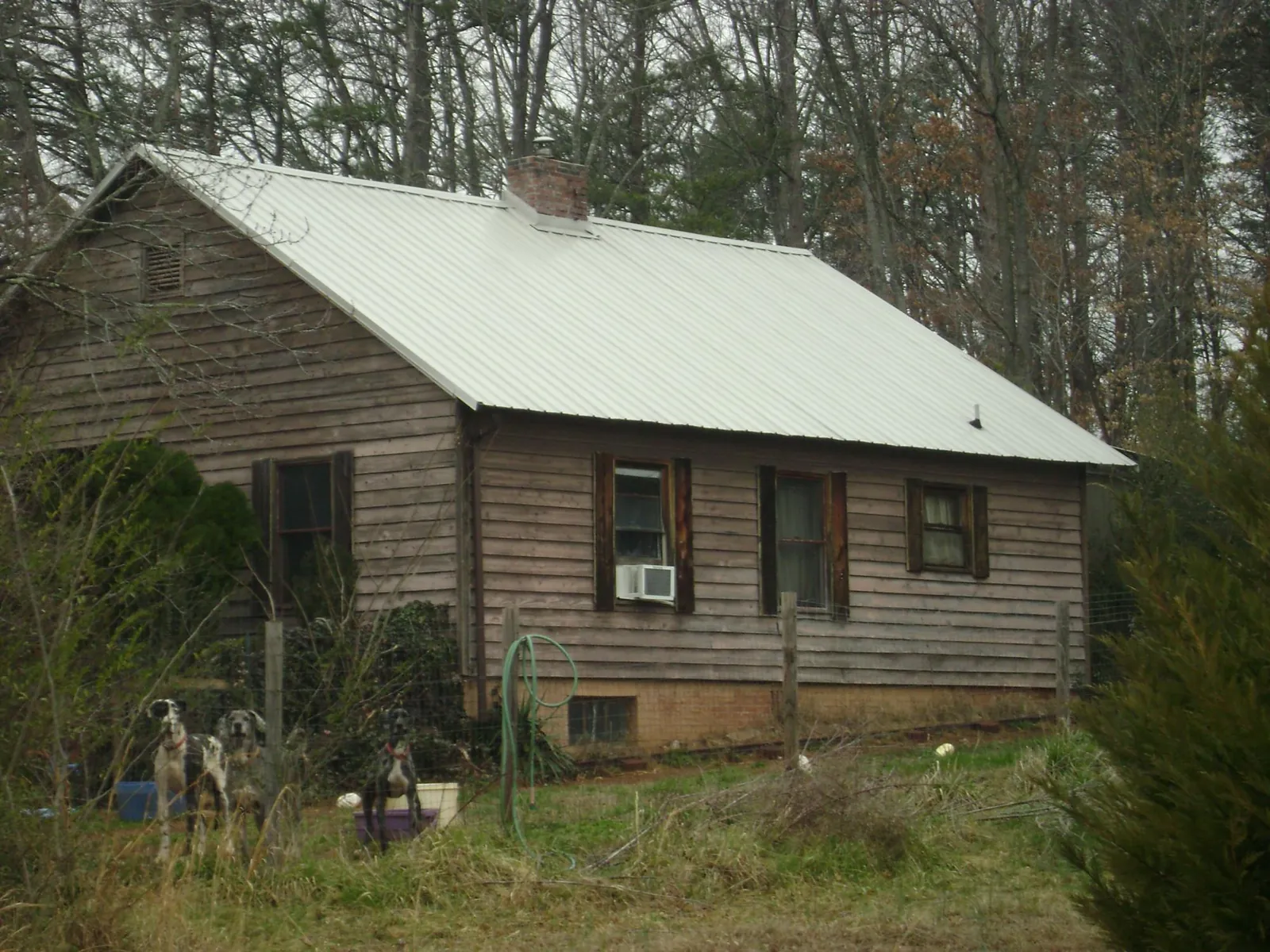 White metal roof on an old wood sided farmhouse, from a Metal Roof Installation job in Saegertown